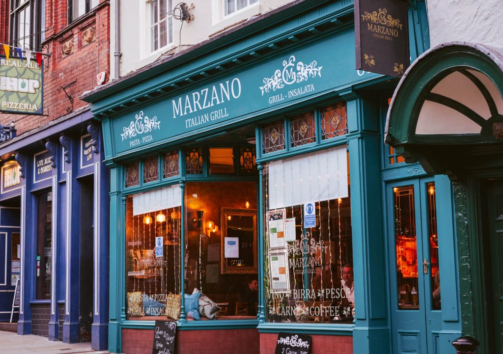 Marzano Italian Grill York exterior on Fossgate, showcasing teal shopfront, Italian restaurant signage, and inviting warm interior.