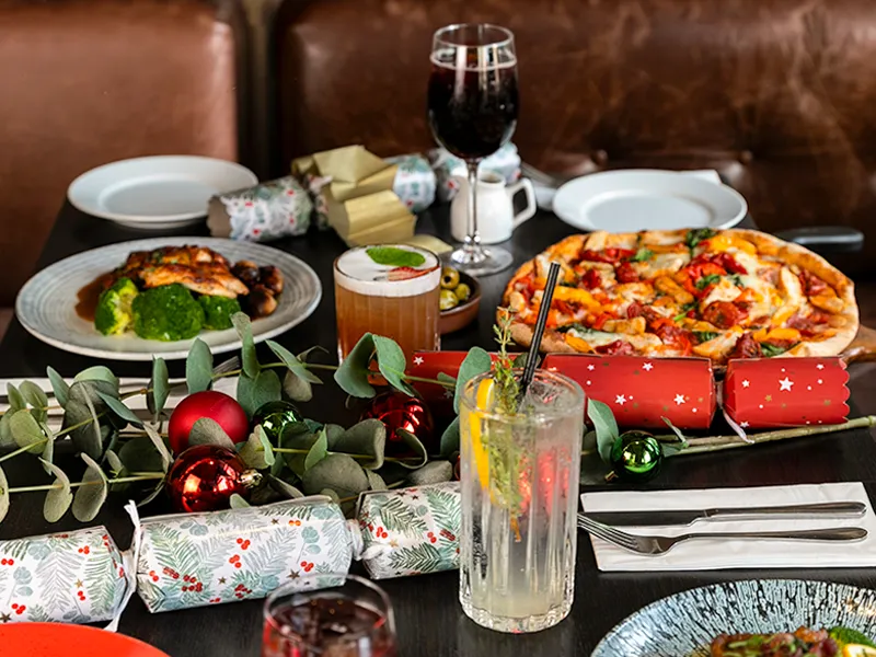 Festive table at Marzano Italian Grill with Italian dishes, drinks and Christmas decorations.